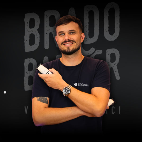 Barbeiro aparando a barba de cliente na barbearia