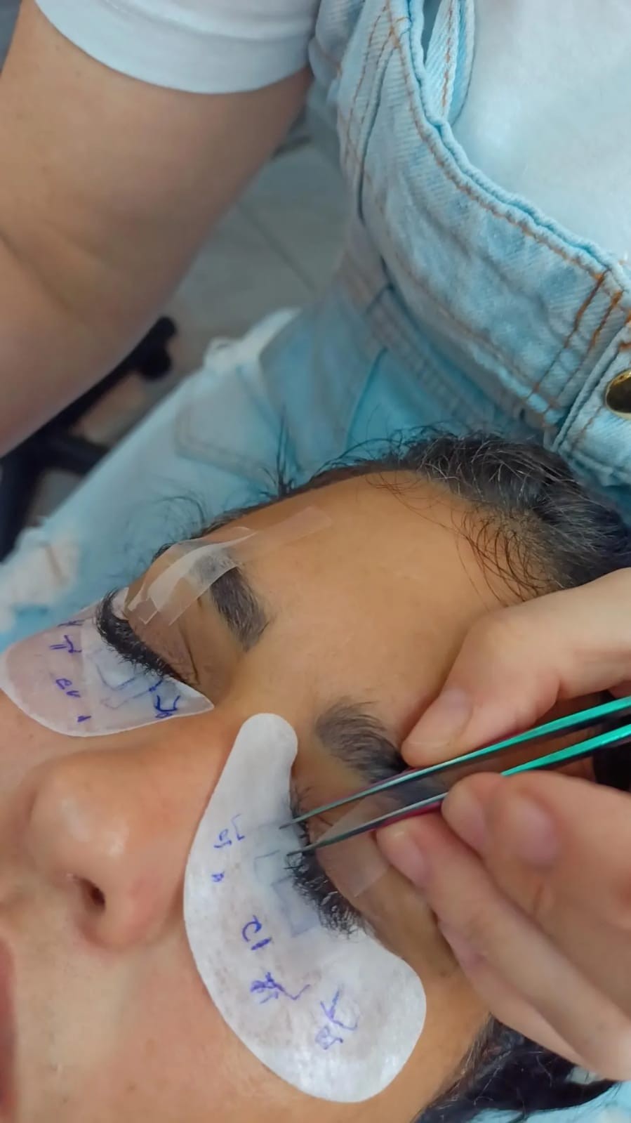 Profissional aplicando Extensão de cílios em cliente